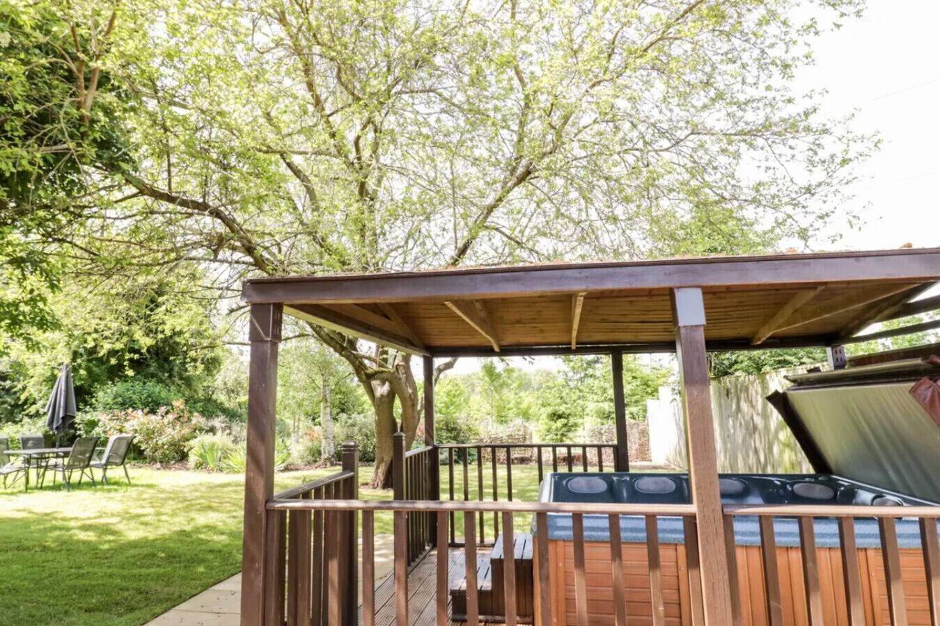 A wooden gazebo with a grill and a barbecue area.