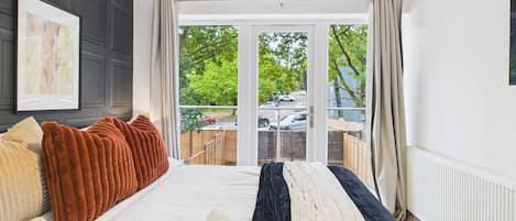 Quarto de hotel com uma cama grande, vista para o exterior e uma janela com cortinas.