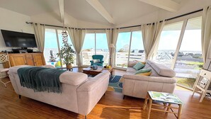 A spacious living room with a large window offering a view of the cityscape.