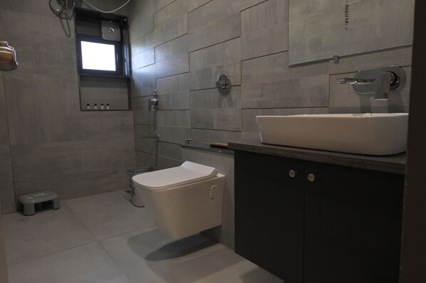 Ein modernes Badezimmer mit Toilette, Waschbecken und Dusche.