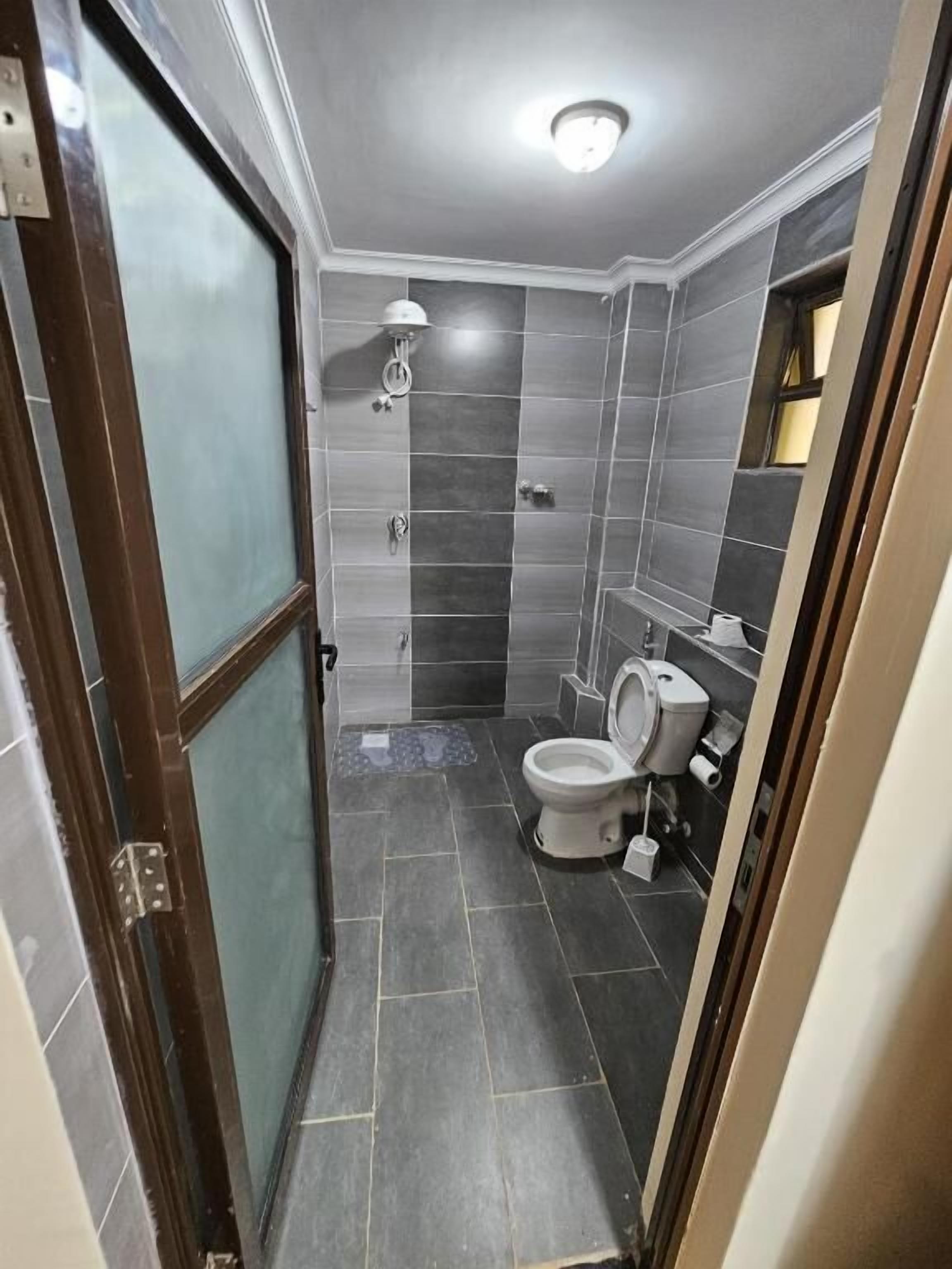Un bagno compatto con doccia, servizi igienici e specchio.