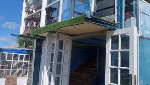Un edificio de varios pisos con un balcón y una escalera que conduce al nivel superior.