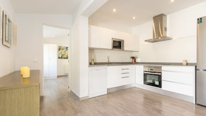 A modern kitchen with white cabinetry, a built-in microwave, oven, and dishwasher. - Villa Casa Blanca in Alcudia by Home Villas 360 (Alcúdia)