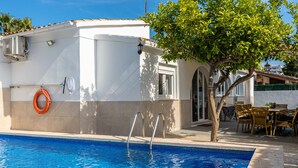 A swimming pool with a ladder, a lifebuoy, and a tree. - Villa Casa Blanca in Alcudia by Home Villas 360 (Alcúdia)