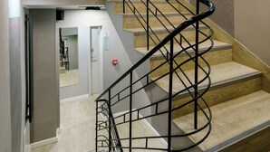 A multi-level interior with a spiral staircase, wooden accents, and patterned walls. - Kamienica no111a (Warsaw)