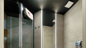A modern bathroom with a glass shower enclosure, a toilet, and a sink. - Kamienica no111a (Warsaw)