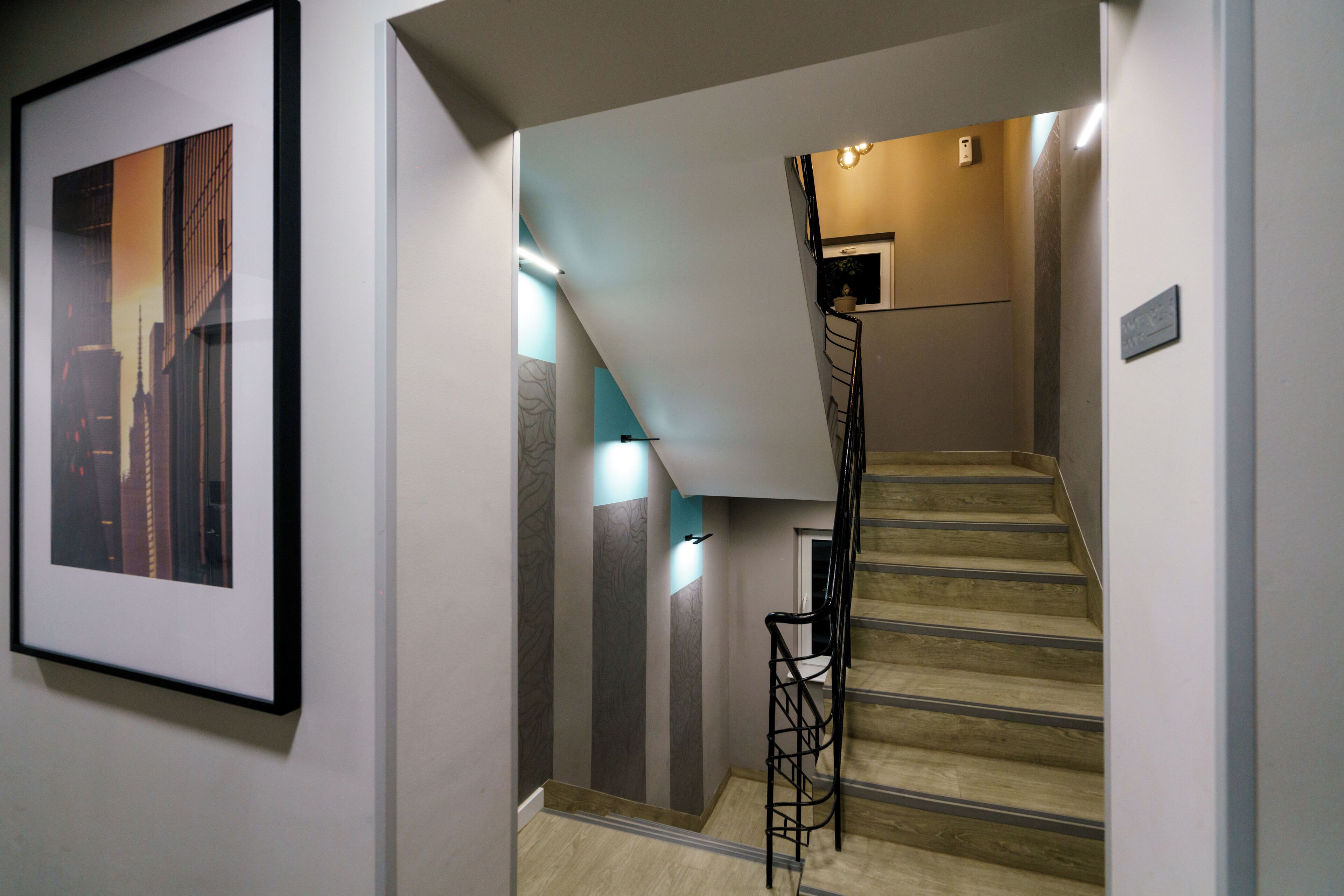 A staircase with a handrail, a framed picture on the wall, and a light fixture above the stairs.