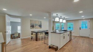 A spacious kitchen with a dining area, wooden flooring, and pendant lighting. - Marvelous Manning: 4-Bdr + Studio + Gameroom (Shad Moss village)