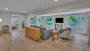 A spacious living room with a sofa set, a wooden cabinet, and a TV. - Marvelous Manning: 4-Bdr + Studio + Gameroom (Shad Moss village)