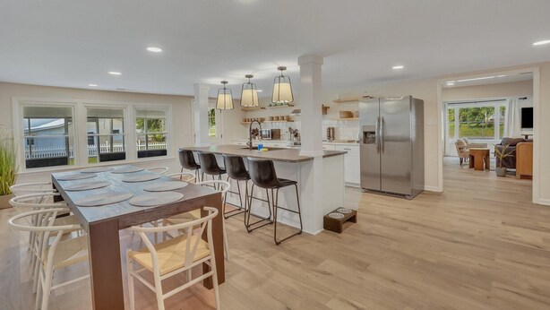 A modern kitchen with a central island, bar stools, and a stainless steel refrigerator. - Marvelous Manning: 4-Bdr + Studio + Gameroom (Shad Moss village)