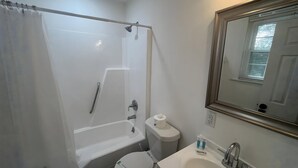 Un baño con bañera, inodoro y lavamanos.