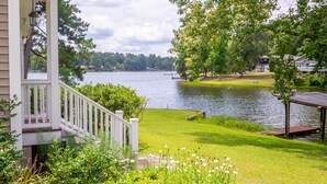 A lakeside property with a porch, dock, and lush greenery. - Tie One On! at 4 Bdr Waterfront Lake Marion (Manning)