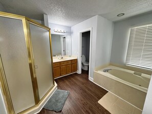 Une salle de bain équipée d’un meuble-lavabo, d’un lavabo, d’un miroir et d’une baignoire.
