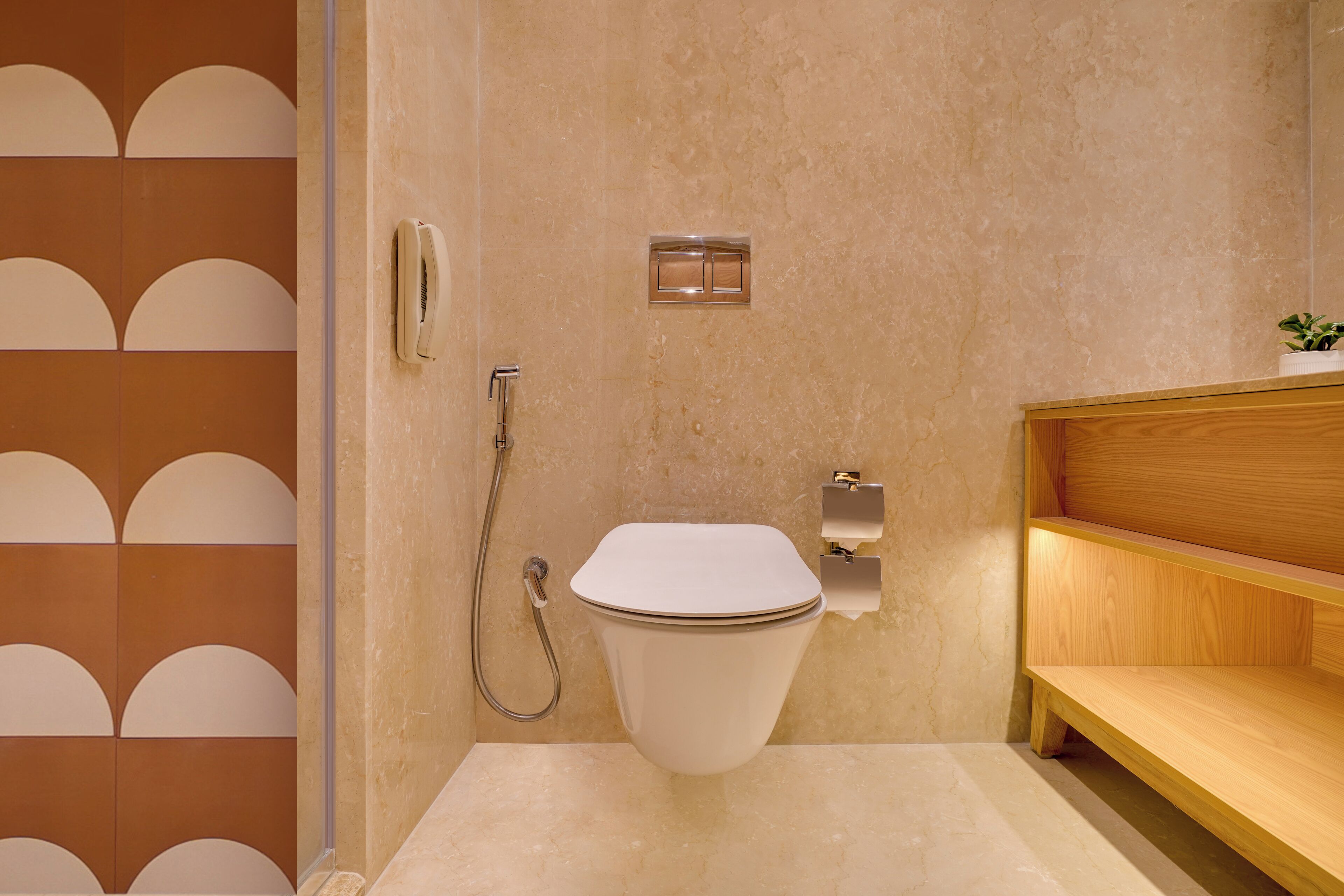 Een moderne badkamer met toilet, douche en een houten wastafelmeubel.