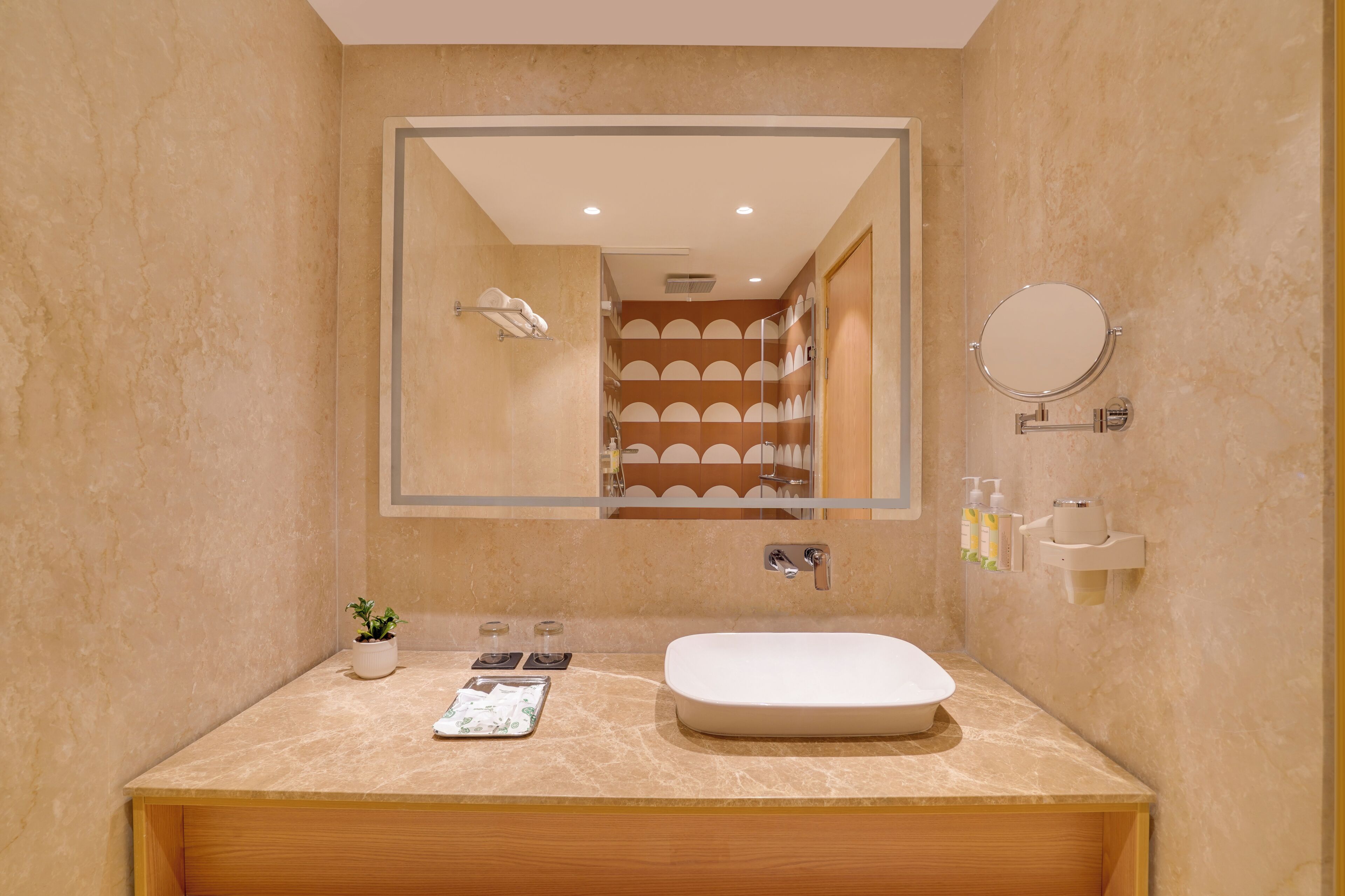 Un bany modern amb un mirall gran, un lavabo i una zona de dutxa.