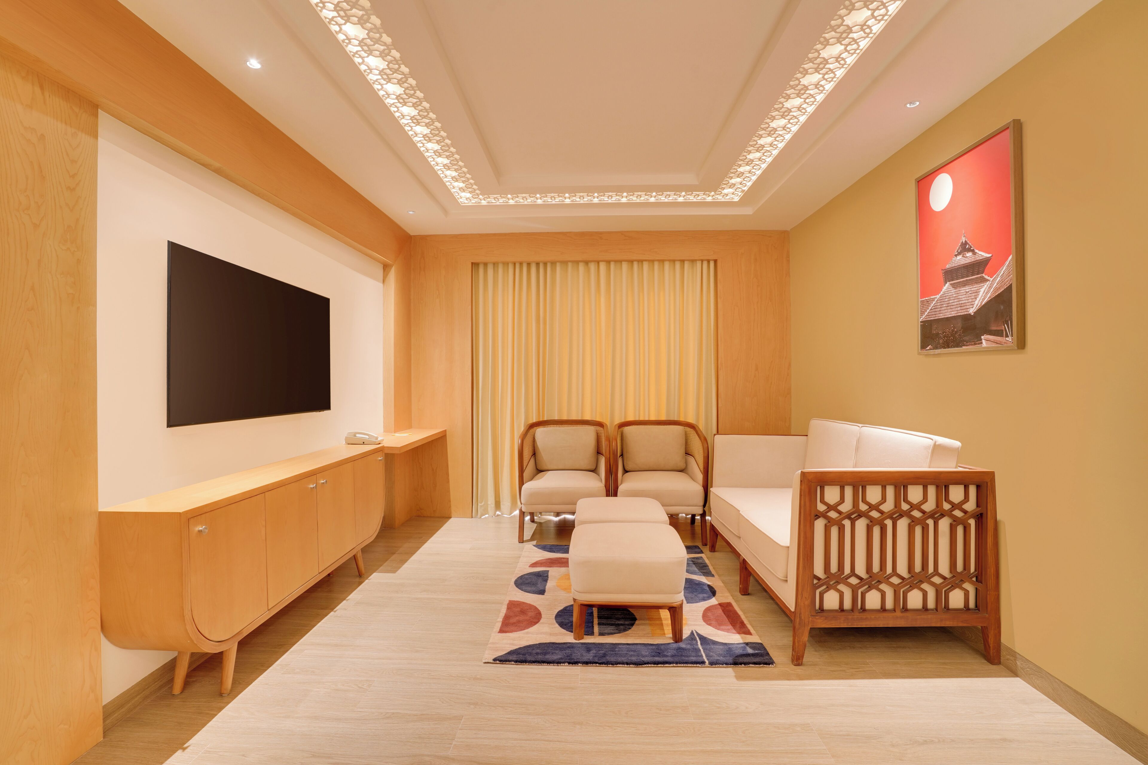 A modern living room with a flat-screen TV, wooden furniture, a sofa, and a decorative wall piece.