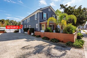 A two-story house with a gravel driveway and a wooden fence.
