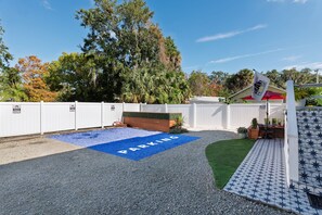 A parking area with a blue mat labeled "PARKING" and a white fence.