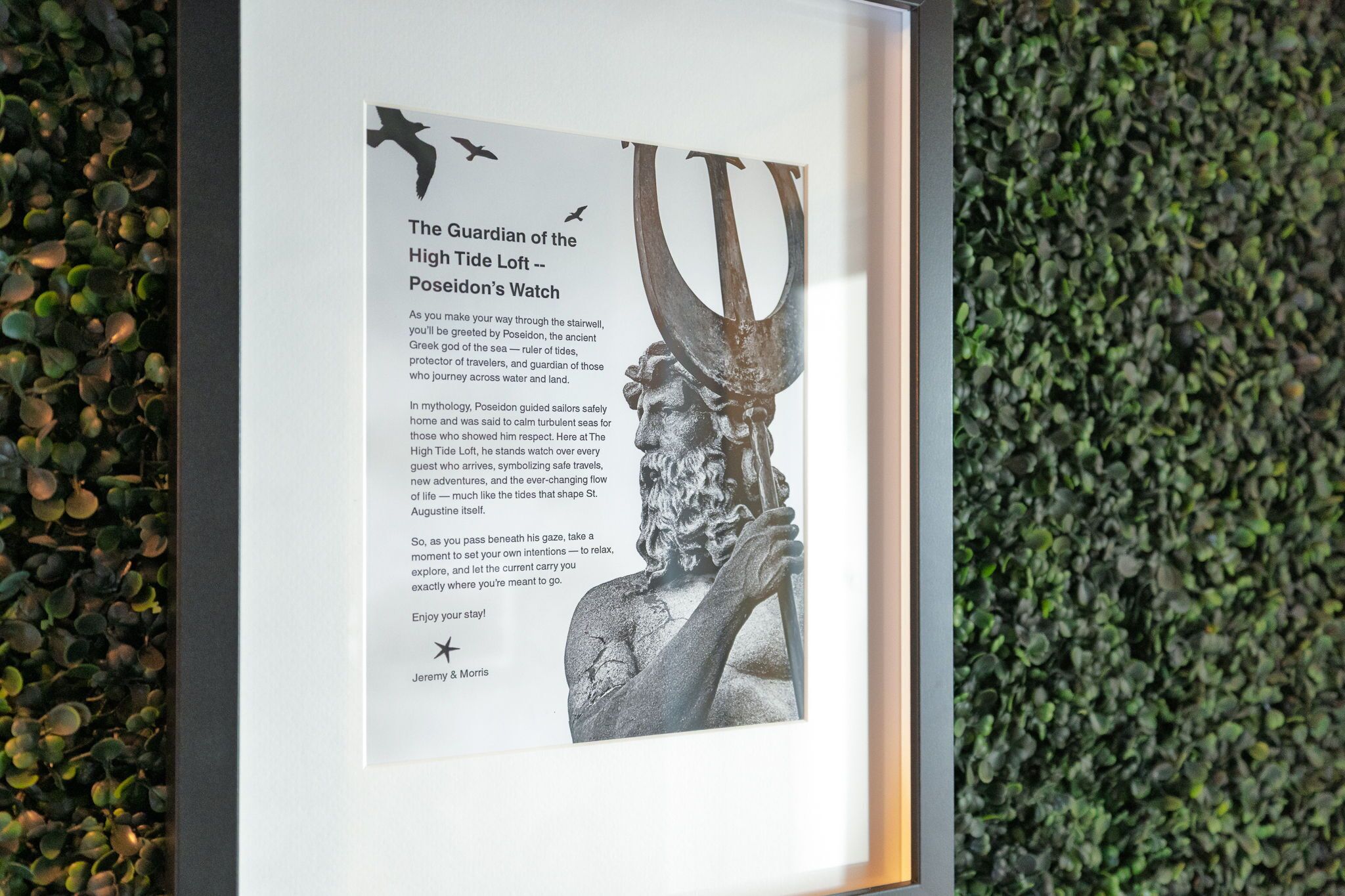 Eine gerahmte Informationstafel mit dem Titel "Der Beschützer des Gezeitenlofts – Poseidons Aussicht", zeigt eine Statue des Poseidon sowie Texte über Mythologie und Sicherheit.