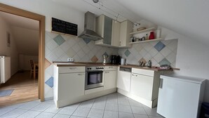 A kitchen with a built-in oven, a dishwasher, and a refrigerator.