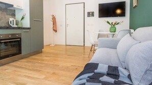 A modern living room with a grey sofa, a coffee table, and a flat-screen TV mounted on the wall. - 2 Combined Flats Near CityLife District (Milan)