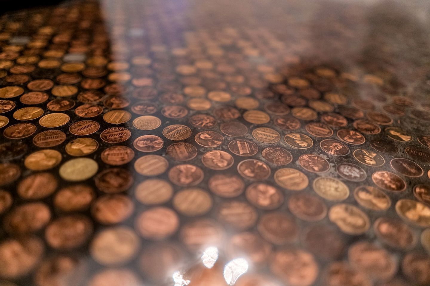 Un primer plano de numerosas monedas con texto y símbolos visibles, dispuestas en un patrón.