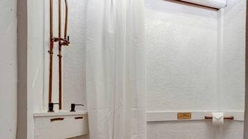 A small bathroom with a shower, toilet, and a sink.