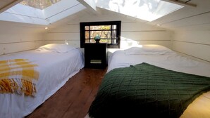 A room with two beds, a skylight, and a window. - Romantic Tree House near Chattanooga in the North Georgia Woodlands (Flintstone)
