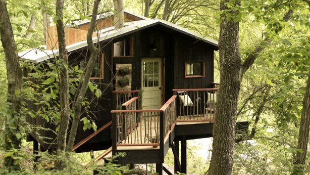 A cabin with a wooden deck, a front door, and a small porch. - Romantic Tree House near Chattanooga in the North Georgia Woodlands (Flintstone)