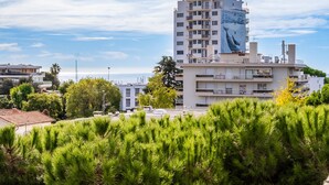 A high-rise building with a mural of a whale on its side, surrounded by greenery and other buildings.