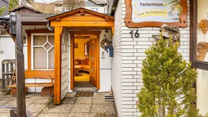 En träbyggnad med en skylt där det står ”Ferienhaus Zum Bachrauschen” och siffran 16.