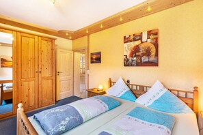 Ein Schlafzimmer mit einem hölzernen Bett, einem Nachttisch, einem Kleiderschrank und einem Gemälde an der Wand.
