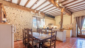 A rustic kitchen with stone walls, wooden beams, and a tiled floor. - Holiday Home “Tomettes” with Mountain View, Wi-Fi and Air Conditioning (Peyraube)