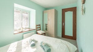 A bedroom with a bed, a window, a wardrobe, and a door. - Gary Loup Holiday Home: Mountain View, Private Terrace, Wi-Fi (sazos)