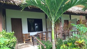 A rustic wooden structure with a thatched roof, surrounded by lush greenery and a small water feature. - Bohol-Lahoy Dive & Beach Resort (Guindulman)