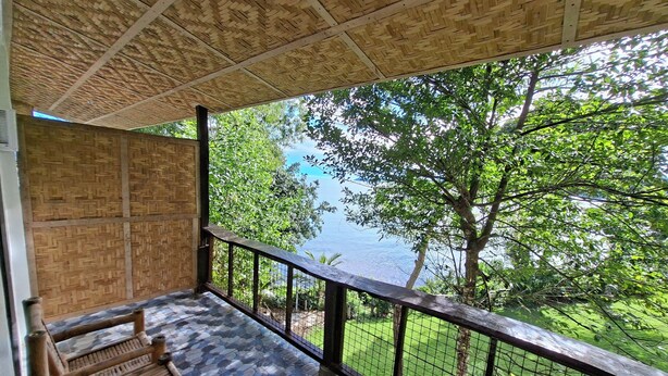 A balcony with a view of a lake, surrounded by greenery. - Bohol-Lahoy Dive & Beach Resort (Guindulman)
