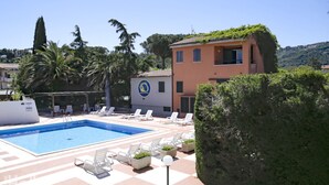 A swimming pool with lounge chairs and a building with a logo.
