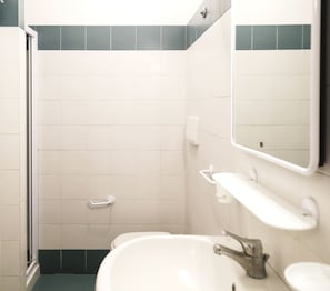 Une salle de bain avec des carreaux blancs, une douche, un lavabo et un miroir.
