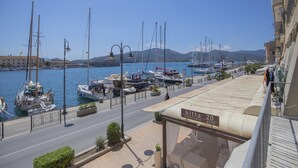 A marina with boats docked, a street in the foreground, and a restaurant named "bitta" with a view of the marina. - Tastefully furnished, it consists of a family room with a double bed and a single bed, a small livin (Portoferraio)