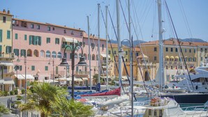 A marina with boats docked, surrounded by colorful buildings with balconies and arched windows. - Tastefully furnished, it consists of a family room with a double bed and a single bed, a small livin (Portoferraio)
