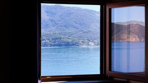 Ein Fenster mit Blick auf einen See und Berge.