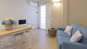 Ein modernes Wohnzimmer mit einem Holzespeisetisch, einem blauen Sofa und einem Fernseher.
