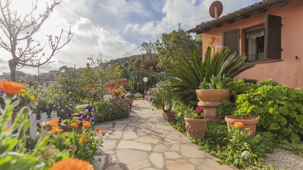 A stone pathway leading to a building with a tiled roof and shutters. - A short distance from the center of Rio Marina, easily reachable on foot, we offer our clients a cha (Rio Marina)