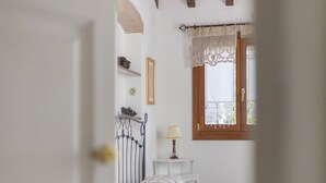 A bedroom with a bed, a nightstand, a window with a curtain, and a wall-mounted lamp. - A short distance from the center of Rio Marina, easily reachable on foot, we offer our clients a cha (Rio Marina)