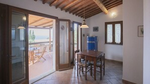 Un espace de vie à aire ouverte avec un plafond en bois, une table à manger et une porte-fenêtre coulissante donnant sur une terrasse extérieure.