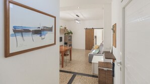 Ein modernes Interieur mit Essbereich, Küche und einem Flur, der zum Schlafzimmer führt.
