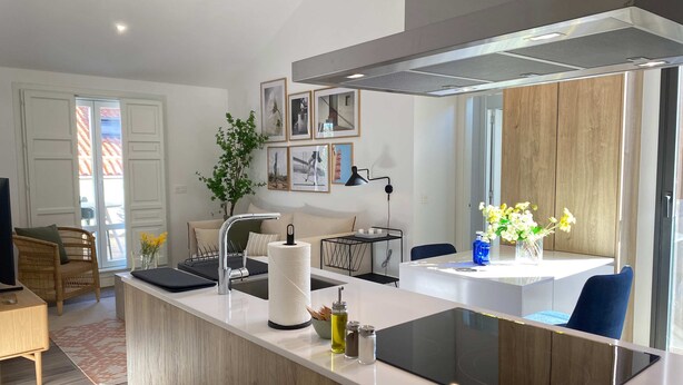 A modern kitchen with a central island, a built-in stove, and a large window. - w Dreamy 1BR With Terrace in Chueca (Madrid)