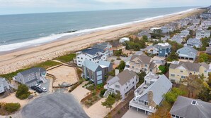 Un quartier résidentiel situé sur la côte, avec des maisons, une plage et une vue sur l’océan.