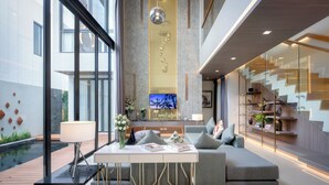 A modern living area with a sofa, a dining table, and a TV.