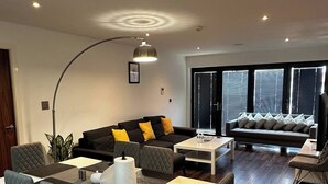 Ein modernes Wohnzimmer mit Essbereich, ausgestattet mit einer Couch, einem Couchtisch und einem Esstisch mit Stühlen.